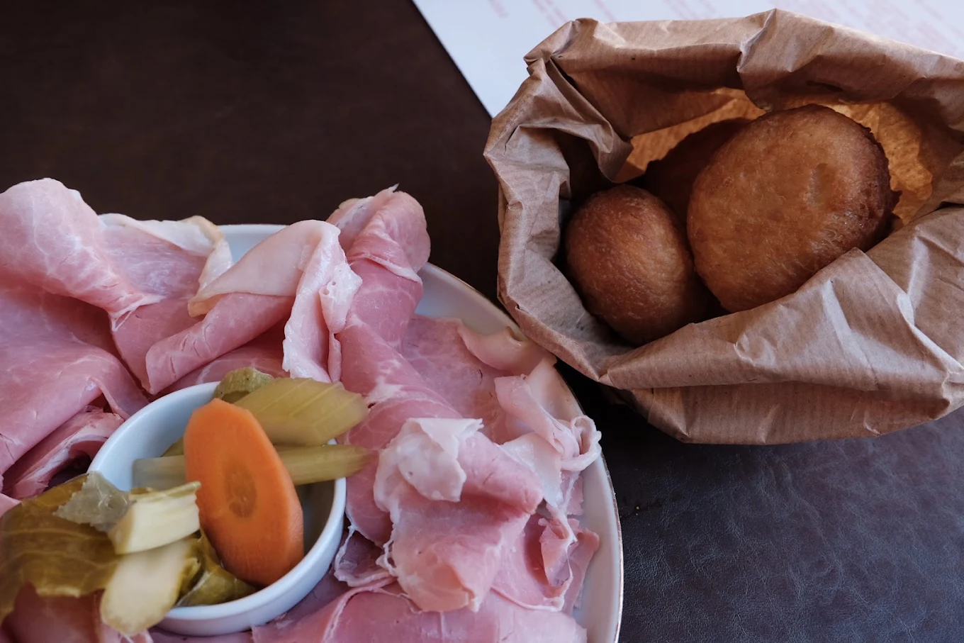 Coccoli fritti serviti nel sacchetto con prosciutto cotto e giardiniera