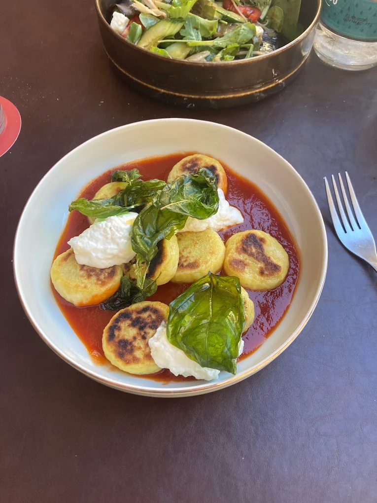 Gnocchi in salsa di pomodoro con stracciatella e basilico fritto