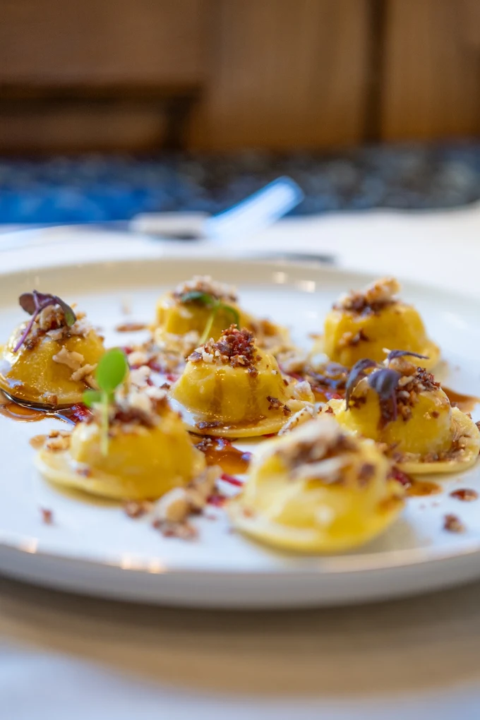 Dettaglio ravvicinato dei ravioli di pasta fresca con granella croccante